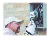 A contractor installs one of the specially-designed meters that will provide WFEC with data about household energy use..