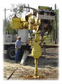 Bonifay linemen drilling: A line construction crew drills the hole to set a pole for a two-span tap.