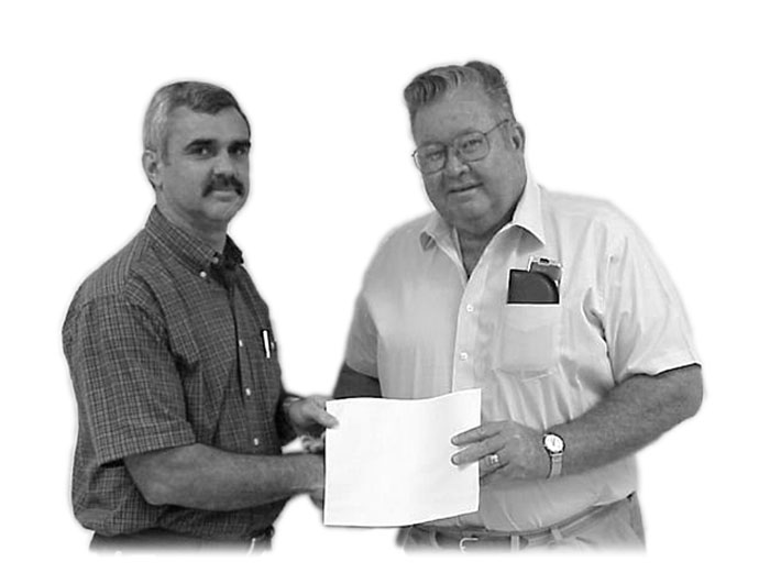 WFEC Board President John E. Worthington, shown at right, presents District 7 Trustee Randy Bush with a Credentialed Cooperative Director Certificate from the National Rural Electric Cooperative Association